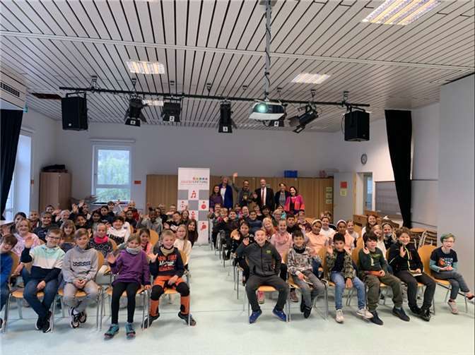 Die Drittklässler aus der Grundschule in Remagen freuen sich sichtlich über das Buch „Im Zeichen der Zauberkugel – Das Abenteuer beginnt“ sowie die Lesung des Autors Stefan Gemmel. Quelle: KSK Ahrweiler
