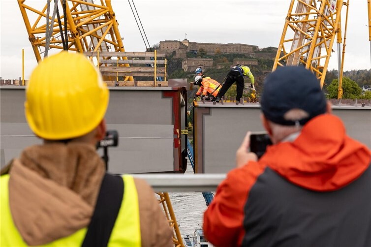 Präzisionsarbeit auf dem Rhein in Koblenz  Die Einhubarbeiten für die neue Pfaffendorfer Brücke haben zahlreiche Schaulustige für Erinnerungsfotos und Videos genutzt.