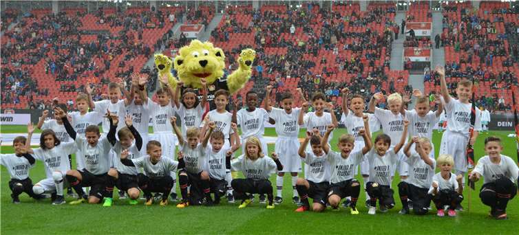 Die Einlaufkinder auf dem Spielfeld der BayArena, zusammen mit dem Maskottchen „Brian, The Lion“.  Bayer 04