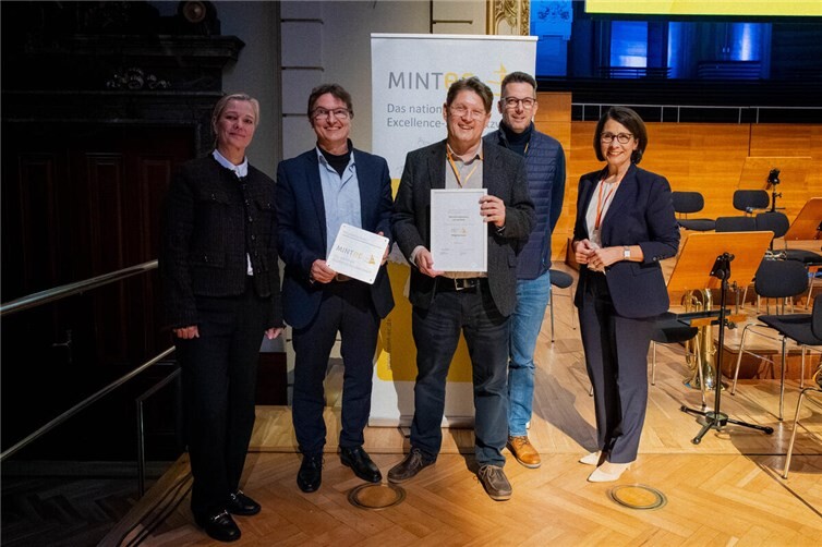 Die Ernennungsurkunde wurde feierlich dem Schulleitungsteam des MGL , Thomas Schmacke, Ralf Weißenfels und Helmut Meixner, überreicht.  Foto: MINT-EC, Schulleitungstagung 2025