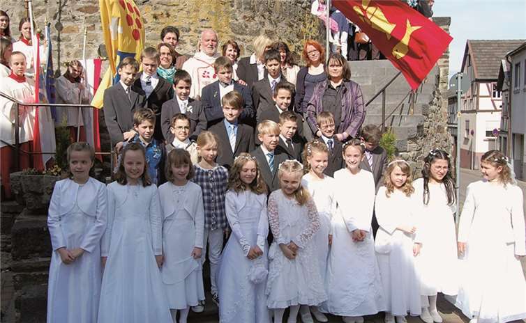 Die Erstkommunikanten mit Pastor Stephan Augst, Pfarrei-Referentin Christel Fassian - Müller, den Katecheten und den Messdienern auf der Freitreppe vor St. Viktor. FA