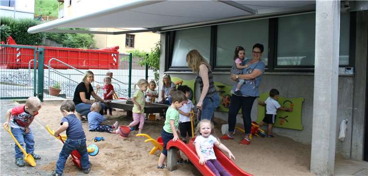 Die Erzieherinnen des U3-Bereichs freuen sich mit den Kindern über den kühlen Schatten durch die neue Markise für den Spielbereich der Kleinsten.privat