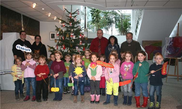 Vorweihnachtliches Ambiente im Foyer Die Erzieherinnen (von links) Yvonne Odenkirchen, Sarah Doll und Conny Steen freuten sich mit der Sonnenkindergruppe des Kindergartens Oberzissen und Bürgermeister Johannes Bell und VG-Mitarbeiter Mike Meder über den toll geschmückten Weihnachtsbaum.WK
