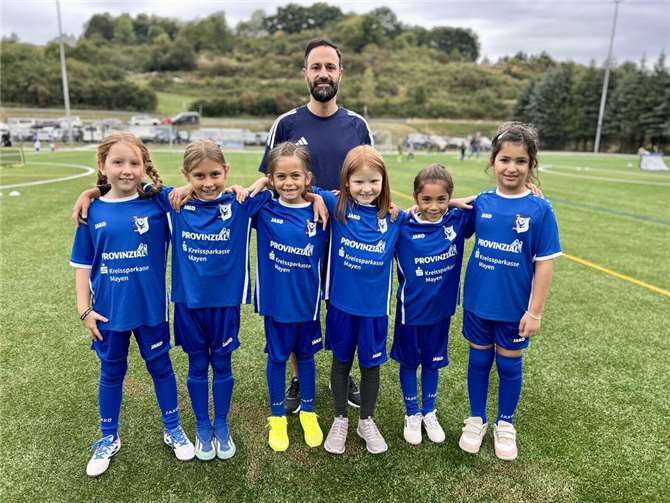 Die F-Jugend Mädels (v. l. n. r.) Elli Schick, Tessa Bicvic, Isabell Schaaf, Malina Enns, Ayla Tertemiz, Shania Osman strahlen bei ihrem ersten offiziellen Einsatz gemeinsam mit Trainer Sinan Tertemiz um die Wette.
