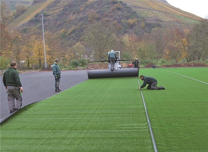 Die Fachfirma bei der Verlegung des Kunstrasens. WITE