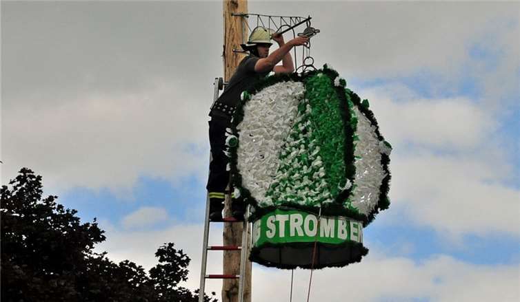 Die Feuerwehr hängt dieschöne Eierkrone am Kirmesbaum auf.