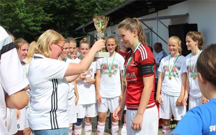 Die Frauenbeauftragte des Fußballkreises Bonn, Bianca Over, überreicht den Pokal an Spielführerin Leah Pingen.