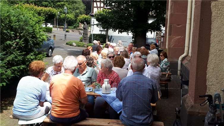 Die Frauengemeinschaft Bassenheim hatte eingeladen und rund 50 Frauen und Männer kamen zum „Ma(h)l halten“ auf dem Walpot-Platz im Schatten der Kirche. Foto: privat