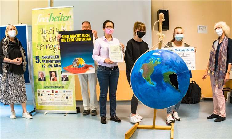 Die Freiheiter-Jurymitglieder Gisela Delis-Ngom (1. v.l.), Gregor Schürer (2.v.l.) mit dem signierten Originalplakat von Prof Klaus Staeck, Katharina Volkert (1.v.r.) überreichten zusammen mit der stellvertretenden Freiheiter-Vorsitzenden Stellvertreterin Ghazel Wahisi (3.v.l.) den beiden Schülersprecherinnen Jasmin Müller (3.v.r.) und Marissa Stuntz (2.v.r.) die Gewinnerurkunde und den Scheck. Fotos: privat