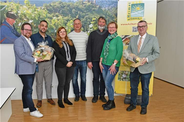 Die Geschäftsführerin Sophie Ewald (3.v.l.), der Vorsitzende Michael Klein (2.v.l.) sowie die Gründungsmitglieder Marie-Theres Neumann (2.v.r.) und Uwe Weber (Mitte) vom Verein „Heimat schmeckt! e.V.“ übergaben Landrat Dr. Alexander Saftig (rechts) und dem Ersten Kreisbeigeordneten Pascal Badziong (links) zwei Präsentkörbe anlässlich des 20-jährigen Jubiläums von „Heimat schmeckt! e.V..“ Dr. Rüdiger Kape (3.v.r.) von der Integrierten Umweltberatung des Kreises freut sich mit allen Beteiligten, dass das Projekt erfolgreich auf eigenen Füßen steht. Foto: Kreisverwaltung MYK/W.Schäfer