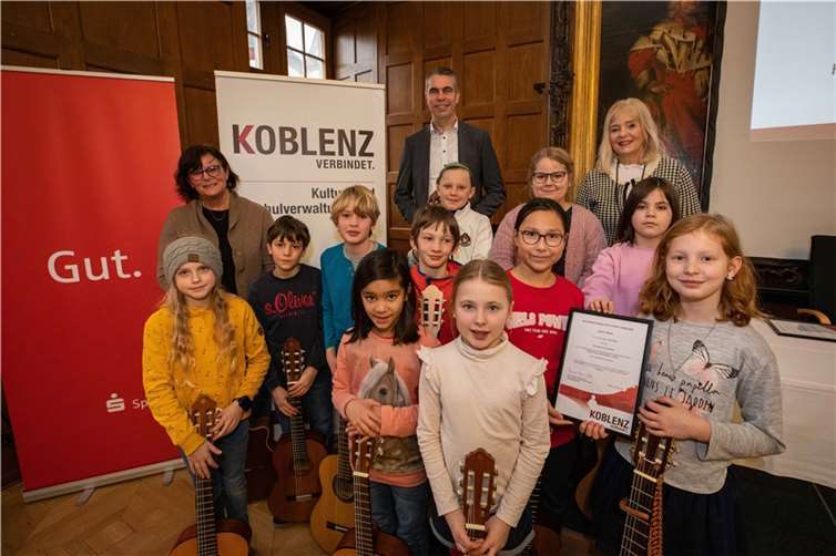 Die Gitarren-AG der Grundschule Arenberg um Schulleiterin Pia Glück (2. von links) gehörte zu den diesjährigen Preisträgern des Schängelpreises, die Frank Roth von der Sparkasse Koblenz (hintere Reihe links) und die Koblenzer Bildungs- und Kulturdezernentin Dr. Margit Theis-Scholz (hintere Reihe rechts) im Rathaussaal auszeichneten.  Fotos: Stadt Koblenz/Andreas Egenolf