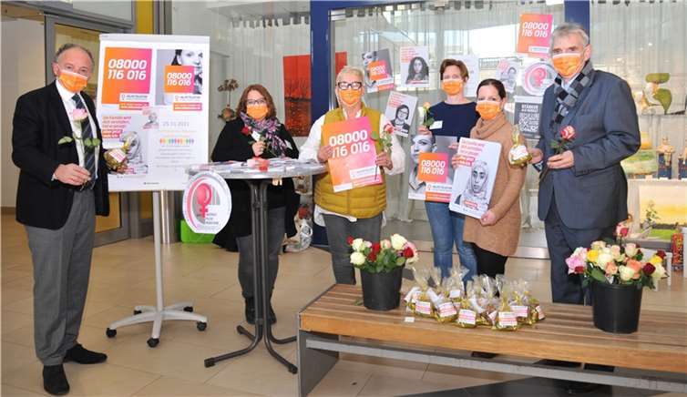 Die Gleichstellungsbeauftragte der Stadt Andernach, Andrea Kohlhaas (3. von links) und Mitarbeiterinnen des Frauenhauses Mayen-Koblenz haben am „Internationalen Tag gegen Gewalt an Frauen“ mit einer Aktion in der Stadthausgalerie Zeichen gesetzt und zum Thema informiert. Außerdem verteilten sie als Zeichen der Wertschätzung Rosen an alle Frauen. Auch Oberbürgermeister Achim Hütten (links) und Bürgermeister Claus Peitz (rechts) unterstützten die Aktion.Foto: Stadt Andernach/Maurer