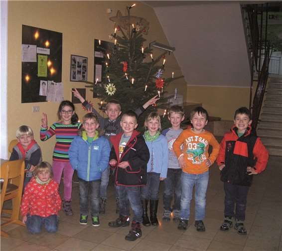 Die Grundschüler des 1. Schuljahres vor dem festlich geschmückten Weihnachtsbaum.privat