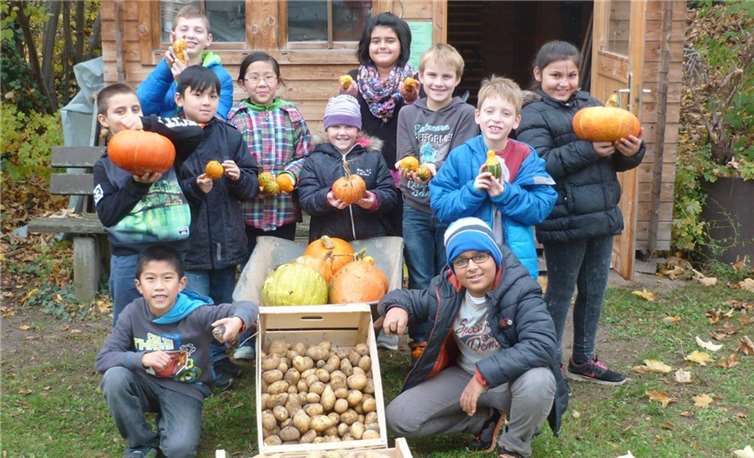Die Grundschüler freuen sich über die erfolgreiche Kartoffel- und Kürbisernte.privat