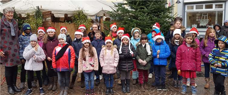 Die GrundschülerInnen sangen auf dem Nikolausmarkt, mit Schulleiterin Anjo Närdemann (li.). privat