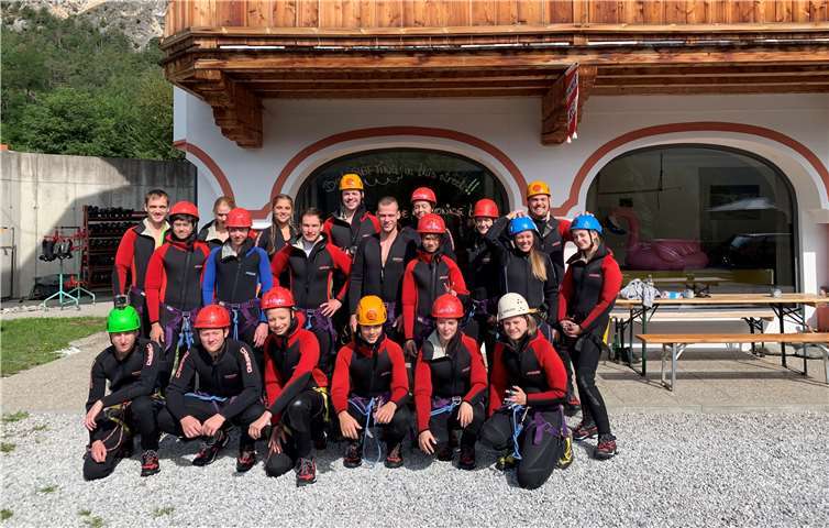 Die Gruppe rüstet sich mit Neoprenanzügen, Helmen und Klettergurten zum Canyoning aus.