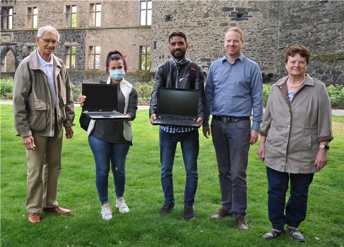 Die „Häcker 60Plus“-Projektmitglieder Klaus König (links) und Heiko Augustin (2. von rechts) übergeben Laptops an Dyani Naoual und Samir Abdelrahman. Darüber freut sich auch ihre Deutschlehrerin Lilly Schmidt.  Foto: Stadt Andernach/Maurer