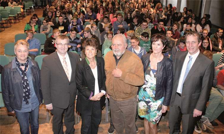 Die IGS-Konrektorinnen Elke Geiermann (l.) und Frauke Wehner (r.) sowie Landrat Dr. Alexander Saftig (l.) und Ideengeber Bürgermeister Maximilian Mumm (r.) mit dem Ehepaar Annette und Dr. Reinhard Erös vor den interessierten Schülerinnen und Schülern der IGS Maifeld im Polcher Forum. WE