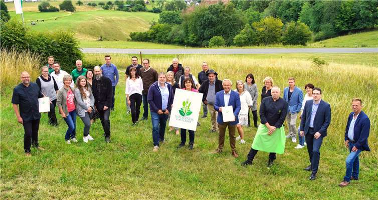 Die Initiatoren der neuen Regionalvermarktungsinitiative „Naturgenuss-Gastgeber“, Jörg Hohnadl von der Kreiswirtschaftsförderung (Mitte links), Irmgard Schröer vom Naturpark Rhein-Westerwald (Mitte) sowie Landrat Achim Hallerbach (Mitte rechts) präsentieren gemeinsam mit Gastronomen und Touristiker das Logo der Initiative.