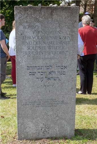 Die Inschrift dieses Gedenksteins auf dem alten jüdischen Friedhof in Heimerzheim, der an die jüdischen Opfer des Nationalsozialismus erinnert, wird von der Informationstafel näher erläutert.