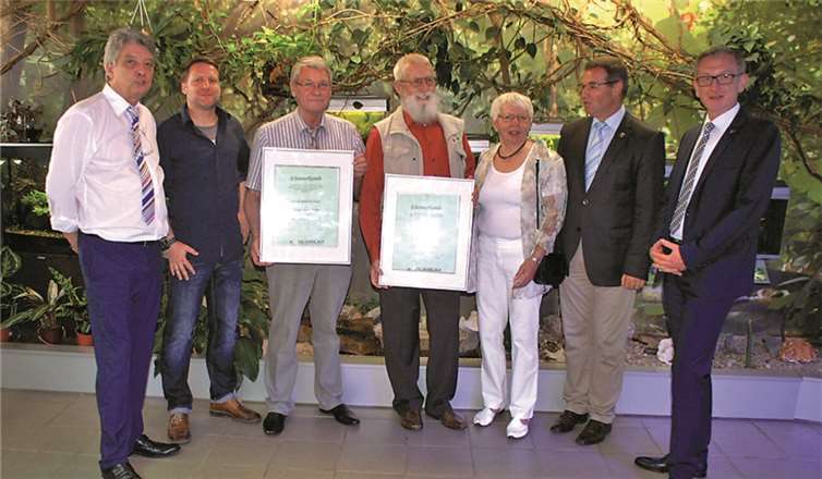 Die Jubilare und ihre Gäste vor der Wand mit asiatischen Fischen (v.li.): Winfried Weber (2. Vorsitzender), Christian Kniel (1. Vorsitzender), Manfred Sangs (mit Urkunde zum Ehrenvorsitzenden), Jochen Brecht (mit Urkunde zum Ehrenmitglied), Heidi Brecht, Horst Gies (Landtagsbeigeordneter) und Guido Orthen (Bürgermeister). SP