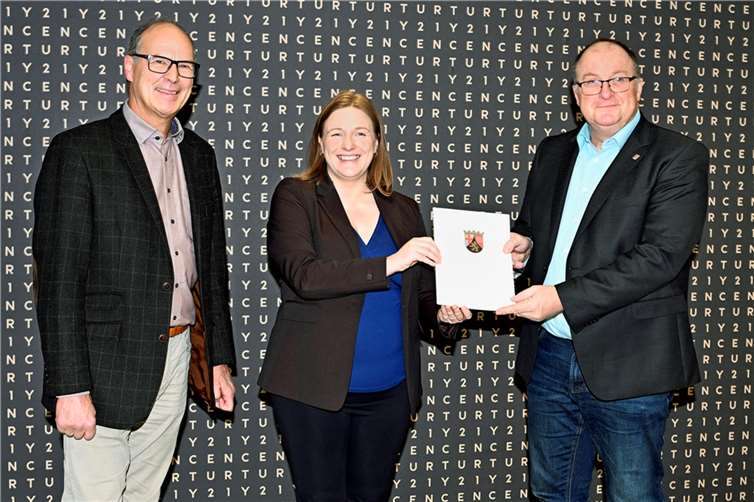 Die Jugendministerin des Landes Rheinland-Pfalz, Katharina Binz, überreichte Verbandsbürgermeister Guido Nisius (re.) im Beisein von Stadtbürgermeister Arnold Hoffmann (li.) den Förderbescheid für das neue Jugendcafé.  Foto: BURG