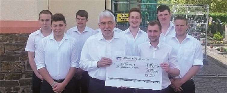 Die Junggesellen überreichten Pastor Hermann Josef Floeck einen Spendenscheck in Höhe von 500 Euro für die Dachsanierung. privat