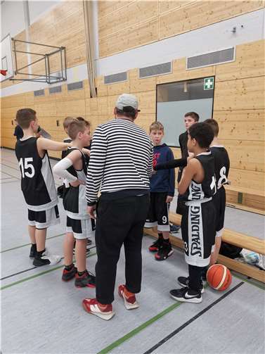 Die Jungs klatschen sich zur Motivation mit ihrem Trainer ab.
