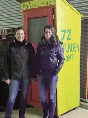Die Jungschützenmeisterinnen Katharina Rosenthal (l.) und Jana Klein vor dem offenen Bücherschrank. privat