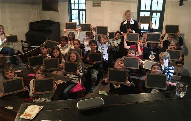 Die KGS-Kinder zeigen stolz ihre Schiefertafeln mit ihrer Sütterlinschrift.