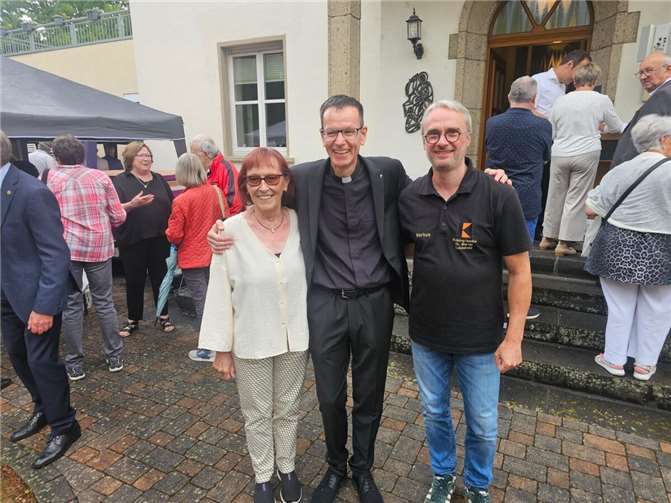 Die Kassiererin Beate Hoffmann und Vorsitzender Markus Schild gratulieren dem spätberufenen Priester, Präses Pfarrer Armin Sturm (Mitte) zum silbernen Priesterjubiläum. Der gebürtige Wirgeser konnte viele Gläubige in der voll besetzten Pfarrkirche und im Pfarrhausgarten begrüßen.