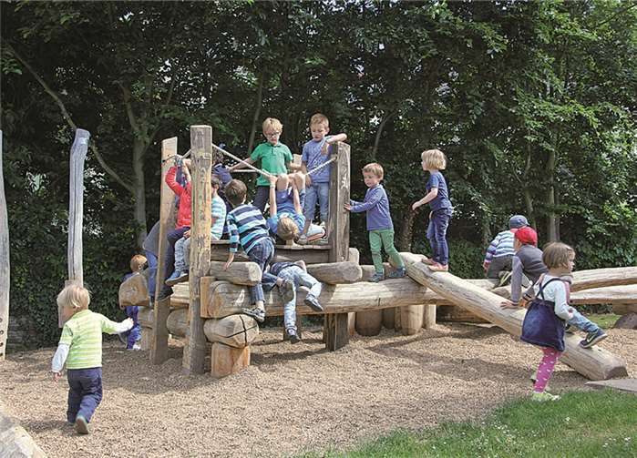 Die Kinder auf ihrem neuen „Baumstammmikado“ im Außengelände des Kindergartens.privat