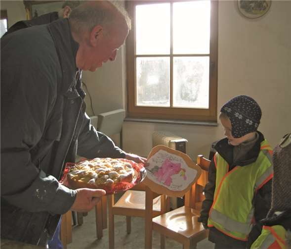 Die Kinder bedankten sich mit einem Kuchen und selbst gemalten Bildern bei den Helfern.
