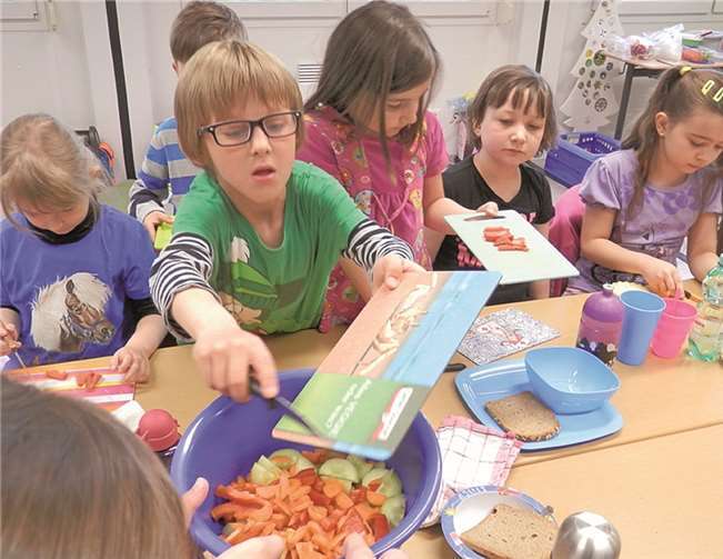 Die Kinder bei der Zubereitung des Obstsalats.privat