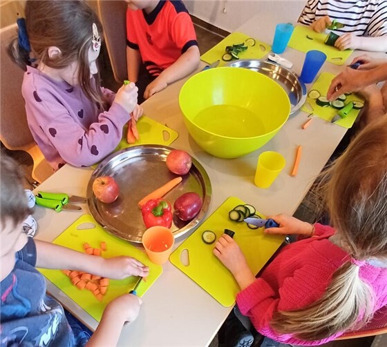 Die Kinder beim Zubereiten der Lebensmittel. Hier lernen sie Tipps und Tricks fürs Kochen und wie man z.B. ein Gemüsemesser richtig hält.