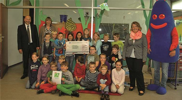 Die Kinder der 2c und Klassenlehrerin Bettina Kempf (2.v.li.) freuten sich sehr über den Besuch von Teilmarktleiter Burkhard Göbel, Kundenberaterin Melanie Schneider und Maskottchen „Kobi“.privat