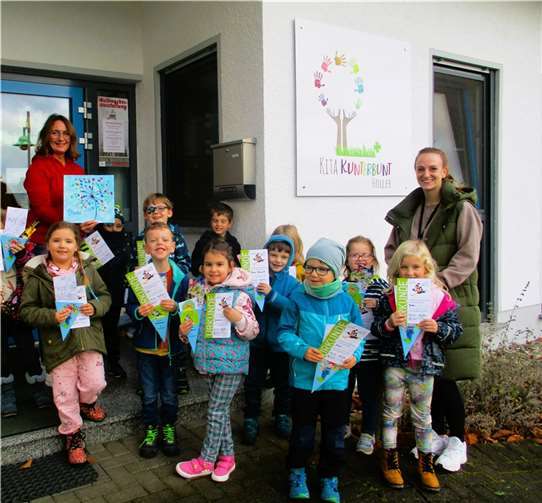Die Kinder der Eichhörnchen-Bande freuen sich über den Bibliotheksführerschein und Büchereimitarbeiterin Angelika Koenen über ein liebevoll gestaltetes Bildgeschenk.  Fotos: privat