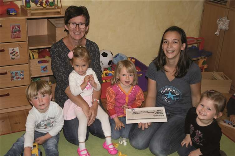 Die Kinder der Elterninitiative „Kleinkinder Wibbelstetz e.V.“ freuen sich mit Erzieherin Kirsten Asmus-Alfert (l.) und Schatzmeisterin Katharina Prior (r.). Bald können sich die Kleinen in einer neuen Nestschaukel vergnügen.