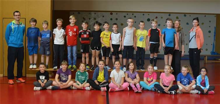 Die Kinder der Handball-AG der Grundschule mit Monika Odrowska (rechts). Zu Besuch kamen F-Jugend-Vereinstrainerin Karin Mintenig und Jugendleiter Thomas Schlich (links).privat