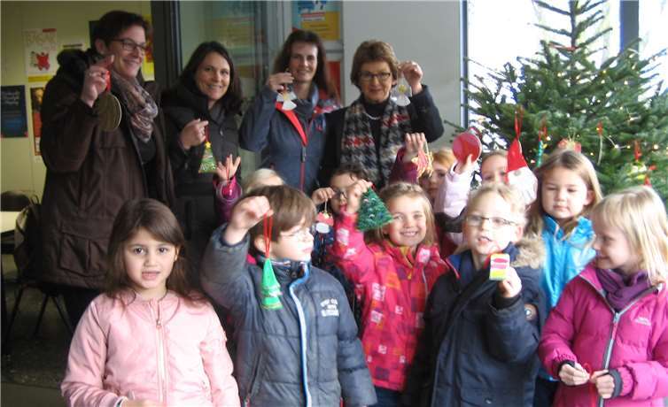 Die Kinder der KiTa „Glühwürmchen“ strahlen mit ihren Erzieherinnen und Bürgermeisterin Renate Offergeld um die Wette mit dem festlich glänzenden Weihnachtsbaum im Rathaus. Gemeinde Wachtberg/ie