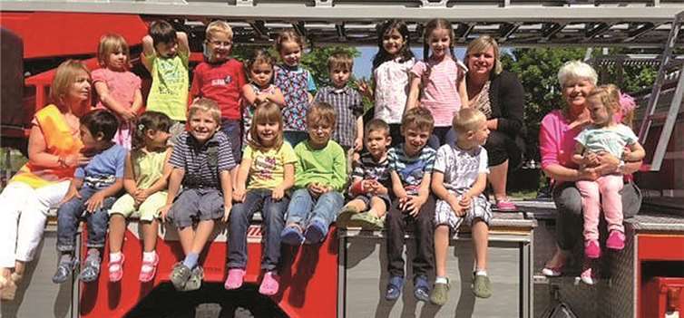 Die Kinder der Kita „Pusteblume“ mit ihren Erzieherinnen auf dem Feuerwehrauto der freiwilligen Feuerwehr Meckenheim.Stadt Meckenheim