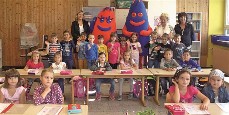 Die Kinder der Klasse 1b mit Stephanie Diensberg, „Lenzi und Kobi“, den Maskottchen der Volksbank Koblenz Mittelrhein, Rektorin Elke Esper und Claudia Kietzmann (v.l.n.r.).privat