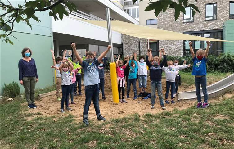 Die Kinder der Klasse 3c und die Schulleiterin Frau Fabritius, präsentieren das neue Sonnensegel. Foto: privat