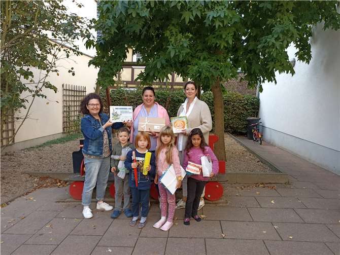 Die Kinder freuen sich mit ihrer Leiterin Viktoria Saleh (m) und Patenzahnärztin Dr. Pamela Husmann (r) über die Auszeichnung, überreicht von Andrea Motz (l) AGZ Ahrweiler