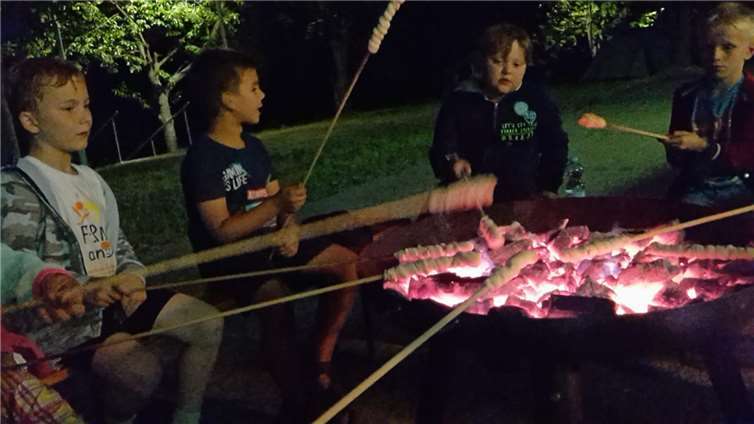 Die Kinder grillen ihr Stockbrot.