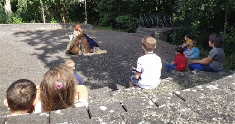 Die Kinder hören begeistert der Märchenerzählerin Griseldis zu. Foto: Familienbildungsstätte