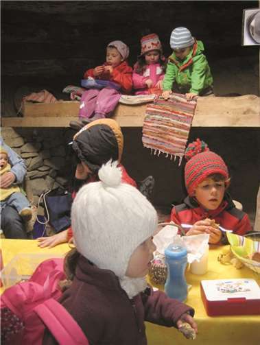 Die Kinder, ihre Familien und Erzieherinnen lassen es sich beim Picknick gutgehen.