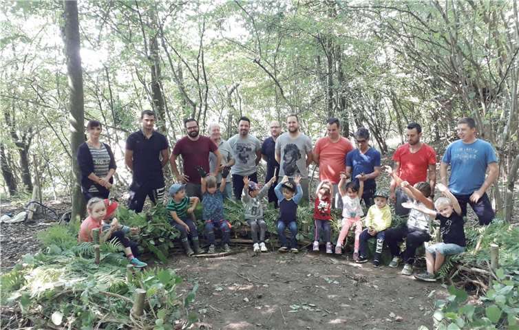 Die Kinder nehmen sichtlich vergnügt Platz auf ihrem neuen Waldsofa, das in einer Gemeinschaftsaktion mit Vätern, Großvätern, anderen Verwandten und Freunden entstanden ist.  Kita Rommersdorf