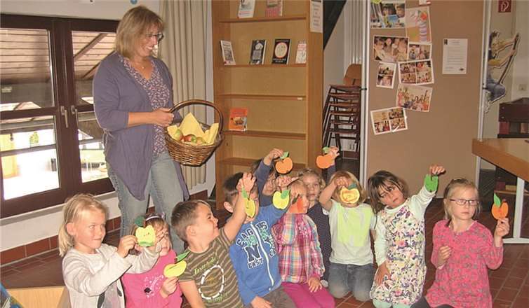 Die Kinder präsentieren stolz ihre selbst bemalten Tonpapieräpfel.privat