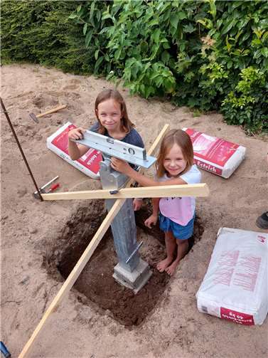 Die Kinder prüfen das Fundament für die neue Wippe.
